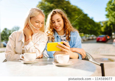 Two young women sitting in the cafe. Coffee break after shopping. Blogging, tourism. Two young women sitting in the cafe. Coffee break after shopping. Blogging, tourism. 114389077