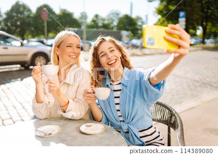 Beautiful woman friends using smartphone selfie together. Fashion, beauty, blogging, tourism. Beautiful woman friends using smartphone selfie together. Fashion, beauty, blogging, tourism. 114389080