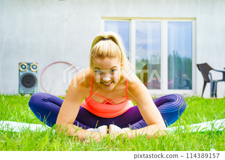 Woman doing exercises gym in garden at home 114389157