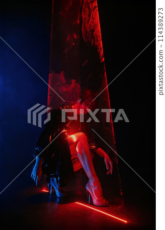 Stylish woman in latex coat under colorful illumination, laser light, neon club. Stylish woman in latex coat under colorful illumination, laser light, neon club. 114389273