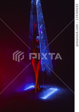 Ballet dancer in pointe under multicolor neon laser light stage. Woman ballerina 114389283