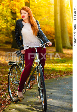 Beauty girl relaxing in autumn park with bicycle, outdoor Beauty girl relaxing in autumn park with bicycle, outdoor 114389329