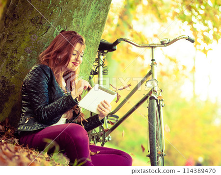 Redhead lady under tree. Redhead lady under tree. 114389470