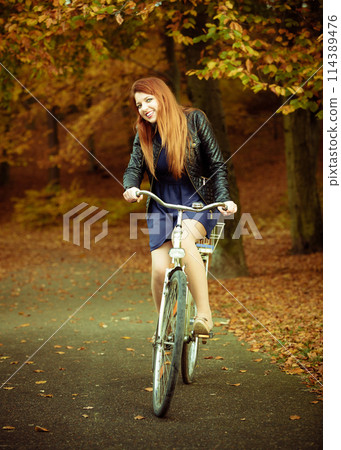 Girl in dress on bike. 114389476