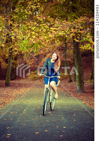 Girl in dress on bike. 114389493