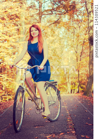 Girl in dress on bike. 114389521