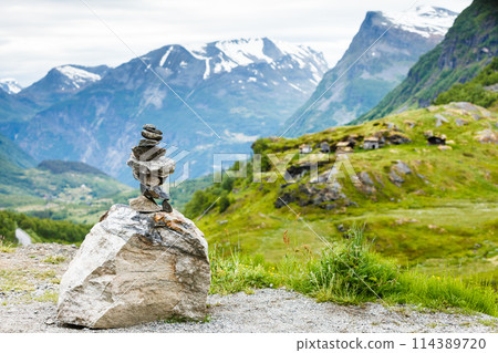 Stone stack and snowy mountain tops, Norway 114389720