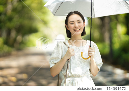 拿著遮陽傘的一個少婦 拿著遮陽傘的一個少婦 114391672