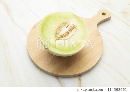Cut Organic Honeydew Melon On Wooden Cutting Board on Granite Table, Cucumis Melo Inodorus Group. Ripe Nutritious Summer Juicy Fruit. Horizontal Plane. Harvesting, Top View 114392061