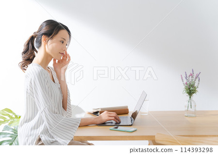 Profile of a woman operating a computer Profile of a woman operating a computer 114393298
