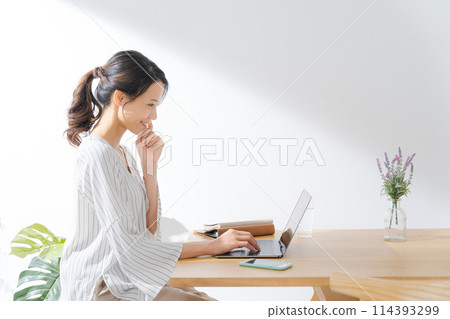 Profile of a woman operating a computer Profile of a woman operating a computer 114393299