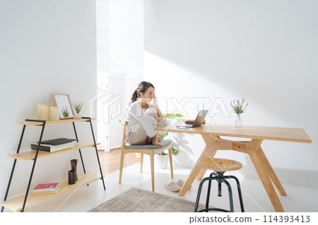 A woman who is depressed looking at a computer A woman who is depressed looking at a computer 114393413