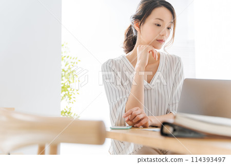 A woman using a computer 114393497