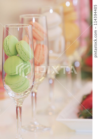 A buffet table lined with macarons and cute sweets 114394405