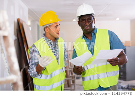 Engineer and architect talking about documents in construction site 114394778
