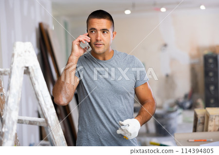Man having telephone convesrtion in construction site 114394805