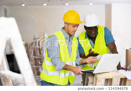 Man builder examining project documentation in apartment 114394876