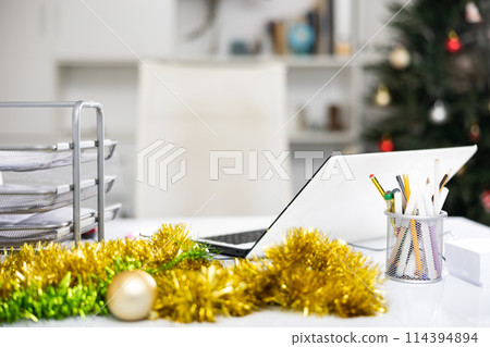 Laptop and christmas tinsel on table in office. Office workplace 114394894