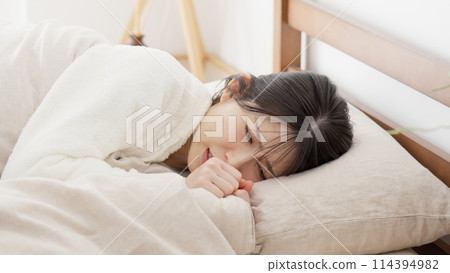 A woman feeling pain in her futon A woman feeling pain in her futon 114394982