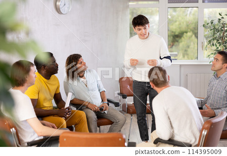 Young man teacher reading lecture for a group of guys 114395009