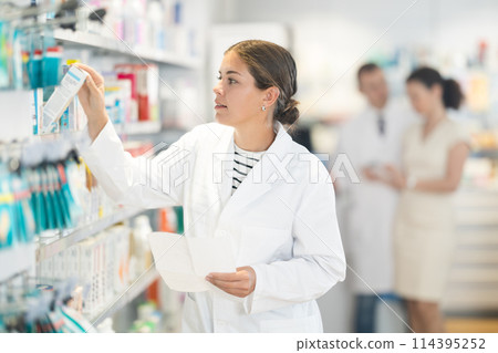 Female pharmacist looking for prescription medicine Female pharmacist looking for prescription medicine 114395252