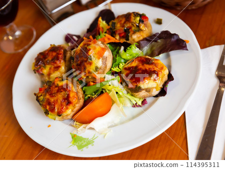 Baked mushrooms stuffed with vegetables, ham and mozzarella Baked mushrooms stuffed with vegetables, ham and mozzarella 114395311