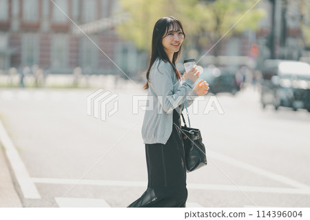 A woman in her 20s with a cute smile walking through the city A woman in her 20s with a cute smile walking through the city 114396004