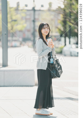 A young working woman in casual clothes standing in an office district A young working woman in casual clothes standing in an office district 114396019