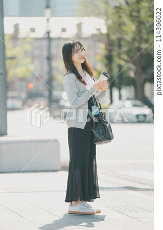 A young working woman in casual clothes walking through an office district A young working woman in casual clothes walking through an office district 114396022