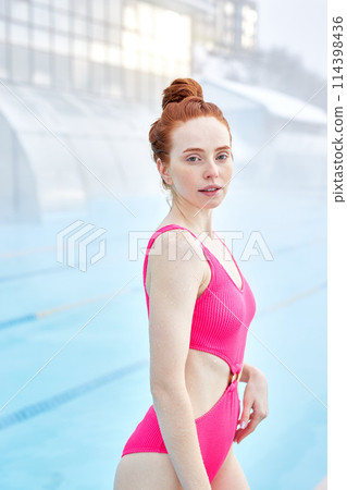 happy sexy young woman with freckles standing at poolside 114398436