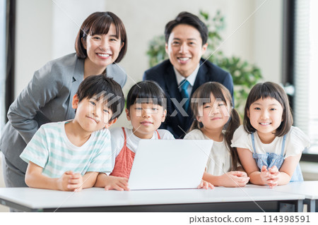 Elementary school students and a teacher taking a programming class at a cram school. 114398591