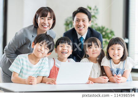 小學生和老師在補習班教授程式設計。 小學生和老師在補習班教授程式設計。 114398594