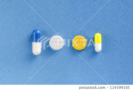 Some pills on blue colored background. Dietary supplements and vitamins Some pills on blue colored background. Dietary supplements and vitamins 114399185