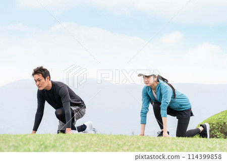 穿著運動服的亞洲男女田徑運動員在公園裡練習短跑和起跑 穿著運動服的亞洲男女田徑運動員在公園裡練習短跑和起跑 114399858