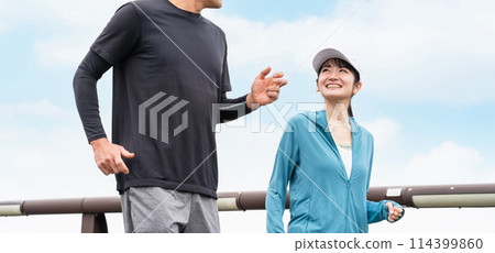 Men and women wearing sportswear walking, strolling and doing aerobic exercise in the park for health 114399860