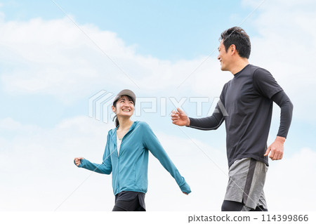 Asian man and woman in sportswear walking, jogging and training while talking in the park (talking) Asian man and woman in sportswear walking, jogging and training while talking in the park (talking) 114399866