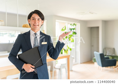 A man who is a planner, salesman, and advisor for a house manufacturer showing around a housing exhibition center and model house 114400040
