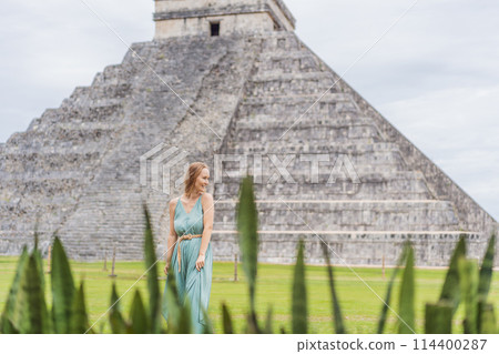 Beautiful tourist woman observing the old pyramid and temple of the castle of the Mayan architecture known as Chichen Itza these are the ruins of this ancient pre-columbian civilization and part of 114400287
