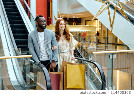 handsome man in glasses and stylish blue suit standing in front of escalator handsome man in glasses and stylish blue suit standing in front of escalator 114400368
