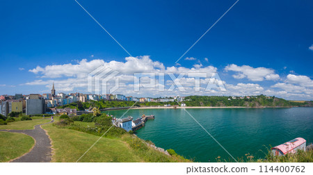 A beach lined with colorful buildings seen from a hilltop (Tenby, Wales, UK) A beach lined with colorful buildings seen from a hilltop (Tenby, Wales, UK) 114400762