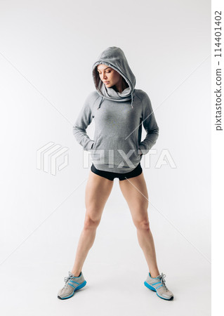 fashionable girl in sweatwear posing to the camera 114401402