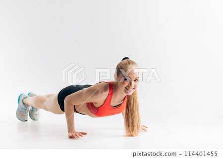 Beautiful slim brunette doing some push ups a the gym 114401455