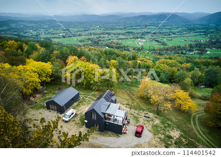 New modern house cottage with solar photovoltaic panel system on roof. Aerial view. Concept of alternative, renewable energy and home autonomy. 114401542