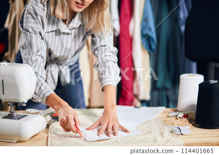 young talented creative female fashion designer working on her designs in studio 114401665