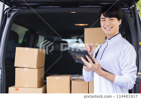 Logistics: A driver checking luggage on a tablet 114401917
