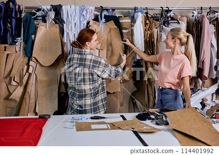 confident female fashion designers doing some work in textile factory, choosing fabric confident female fashion designers doing some work in textile factory, choosing fabric 114401992
