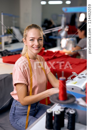 Textile cloth factory working process tailoring modern clothes, young woman at work 114402059