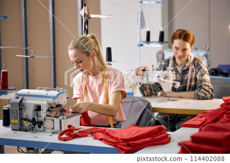 Young happy women working as seamstress in clothing factory, clothing production concept 114402088