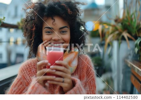 Cheerful Woman Enjoying Warm Beverage Outdoors 114402580