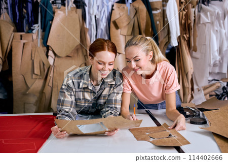 women at garment factory, discussing the work, have talk about new clothing, at workshop women at garment factory, discussing the work, have talk about new clothing, at workshop 114402666